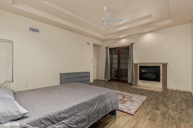 6859 N Placita Chula Vis, Tucson, AZ 85704 - bedroom featuring a tray ceiling, wood finished floors, recessed lighting, and a fireplace with flush hearth