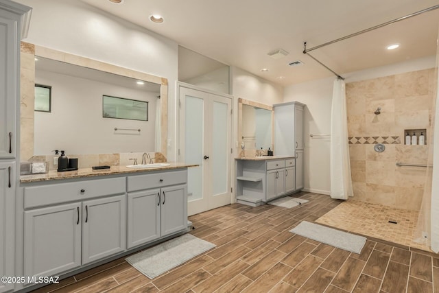 6859 N Placita Chula Vis, Tucson, AZ 85704 - full bathroom featuring a tile shower, wood finished floors, vanity, and recessed lighting