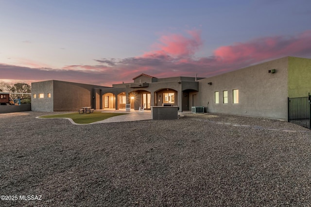 6859 N Placita Chula Vis, Tucson, AZ 85704 - back of property at dusk with stucco siding and a patio area