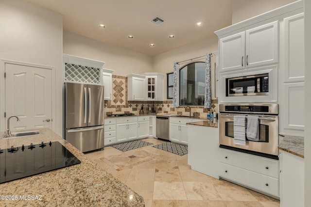 6859 N Placita Chula Vis, Tucson, AZ 85704 - kitchen featuring appliances with stainless steel finishes, light stone countertops, tasteful backsplash, white cabinets, and recessed lighting
