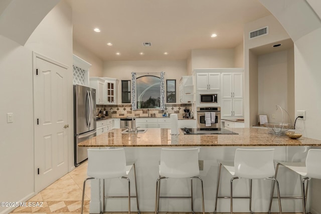 6859 N Placita Chula Vis, Tucson, AZ 85704 - kitchen with appliances with stainless steel finishes, white cabinetry, a breakfast bar area, and recessed lighting
