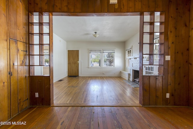 642 E 2nd St, Tucson, AZ 85705 - unfurnished living room featuring wood-type flooring and a fireplace