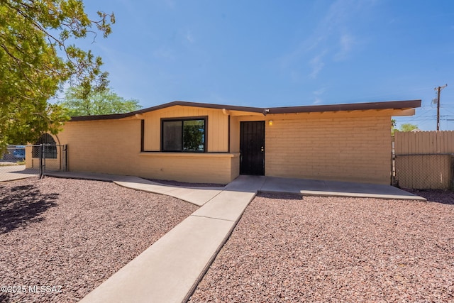 325 W Santa Maria St, Tucson, AZ 85706 - view of front facade featuring a gate, brick siding, and a patio area