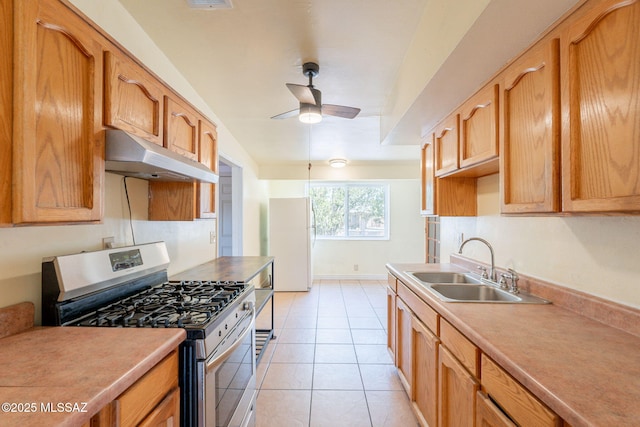 325 W Santa Maria St, Tucson, AZ 85706 - kitchen featuring gas range, under cabinet range hood, freestanding refrigerator, a ceiling fan, and light countertops
