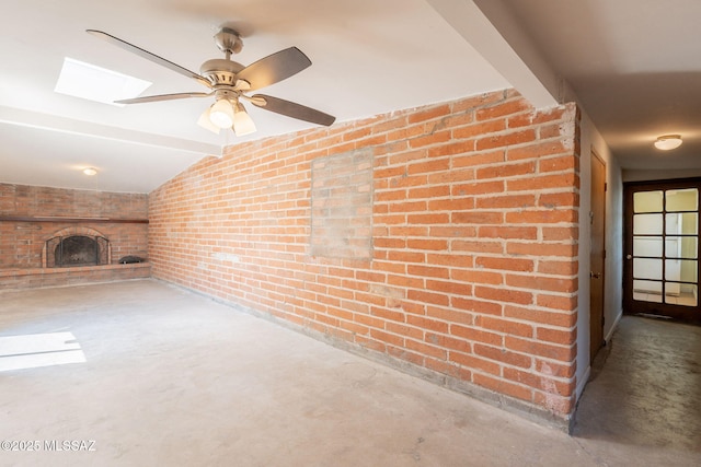 325 W Santa Maria St, Tucson, AZ 85706 - unfurnished living room featuring brick wall, a large fireplace, vaulted ceiling, concrete floors, and a skylight