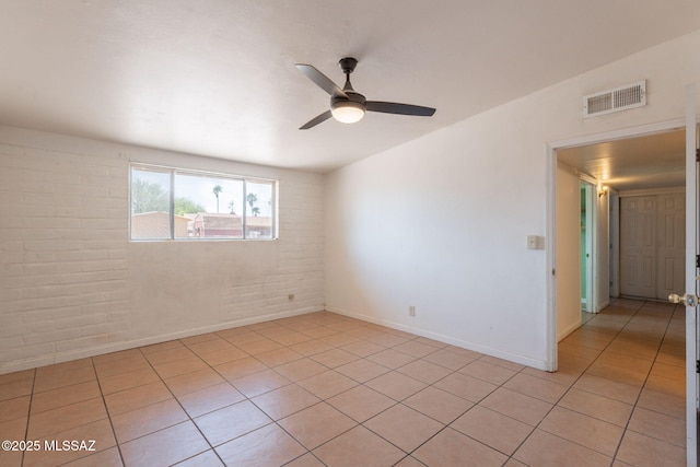 325 W Santa Maria St, Tucson, AZ 85706 - spare room with ceiling fan, light tile patterned floors, and brick wall