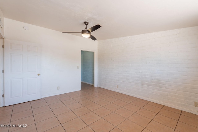 325 W Santa Maria St, Tucson, AZ 85706 - empty room featuring brick wall, ceiling fan, and light tile patterned flooring