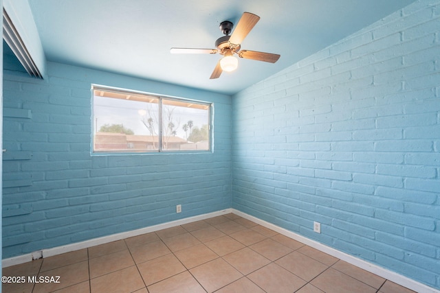 325 W Santa Maria St, Tucson, AZ 85706 - empty room with a ceiling fan, lofted ceiling, brick wall, and light tile patterned floors