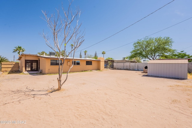 325 W Santa Maria St, Tucson, AZ 85706 - back of house with french doors, brick siding, and a storage shed