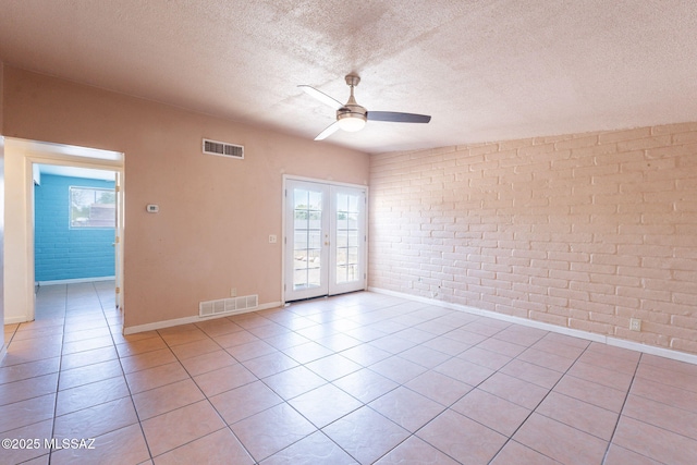 325 W Santa Maria St, Tucson, AZ 85706 - tiled spare room featuring brick wall, a ceiling fan, french doors, and a textured ceiling