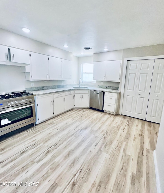 1105 S 1st Ave, Safford, AZ 85546 - kitchen with stainless steel appliances, light wood-type flooring, white cabinets, and recessed lighting