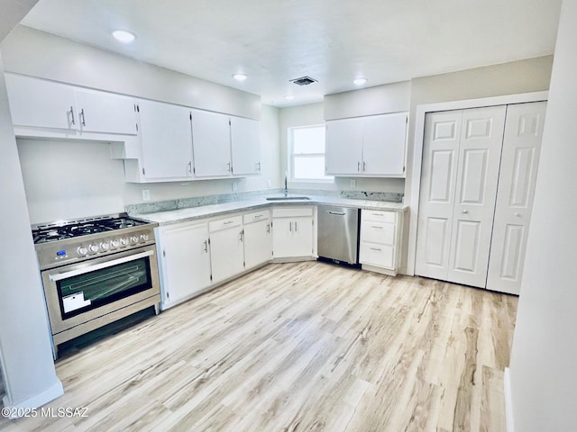 1105 S 1st Ave, Safford, AZ 85546 - kitchen with stainless steel appliances, white cabinets, light wood-style flooring, and recessed lighting