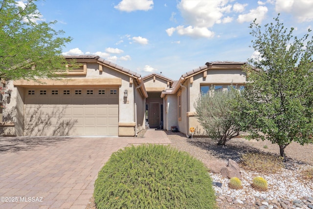 8470 N Gaetano Loop, Tucson, AZ 85742 - view of front facade with decorative driveway, stucco siding, a garage, and a tiled roof