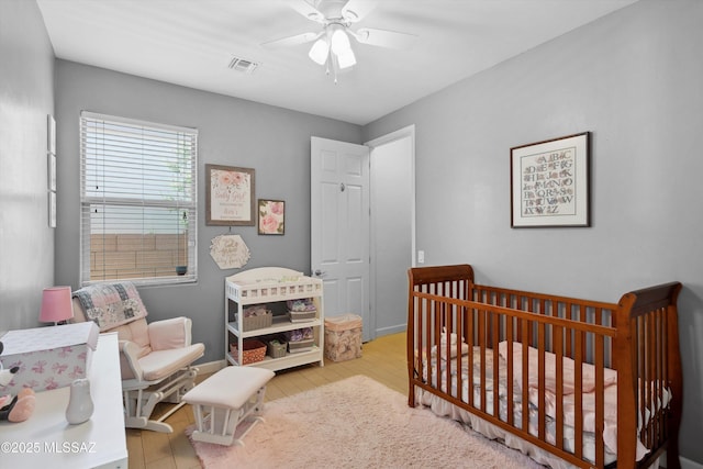 8470 N Gaetano Loop, Tucson, AZ 85742 - bedroom with a crib, wood finished floors, and a ceiling fan