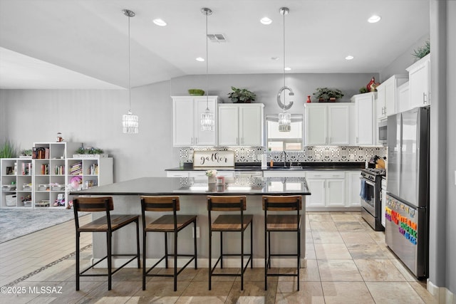 8470 N Gaetano Loop, Tucson, AZ 85742 - kitchen featuring appliances with stainless steel finishes, backsplash, white cabinets, vaulted ceiling, and recessed lighting