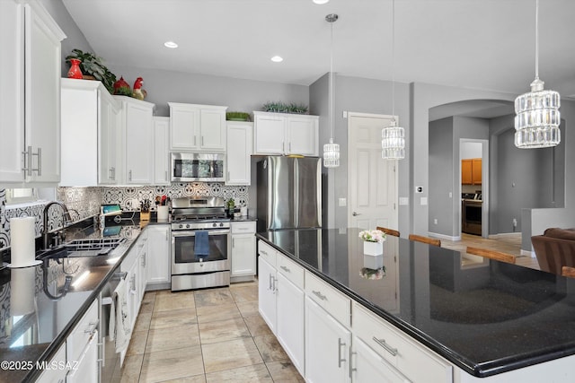 8470 N Gaetano Loop, Tucson, AZ 85742 - kitchen with appliances with stainless steel finishes, decorative backsplash, arched walkways, white cabinets, and recessed lighting
