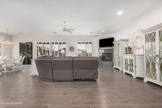 5371 W Leatherflower Ln, Marana, AZ 85658 - living area featuring a glass covered fireplace, a chandelier, a ceiling fan, wood finished floors, and recessed lighting