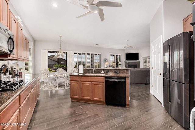 5371 W Leatherflower Ln, Marana, AZ 85658 - kitchen featuring appliances with stainless steel finishes, ceiling fan, a fireplace, a chandelier, and recessed lighting
