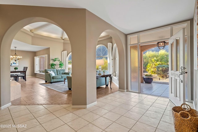 6265 N Jochums Dr, Tucson, AZ 85718 - foyer with light tile patterned flooring, plenty of natural light, a chandelier, and arched walkways