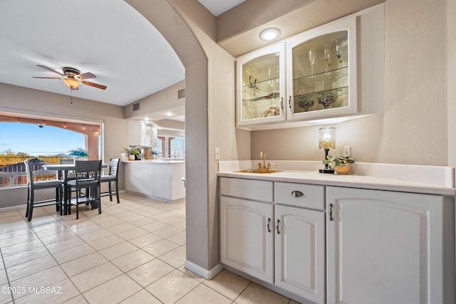 6265 N Jochums Dr, Tucson, AZ 85718 - indoor wet bar with light tile patterned flooring, a ceiling fan, and arched walkways