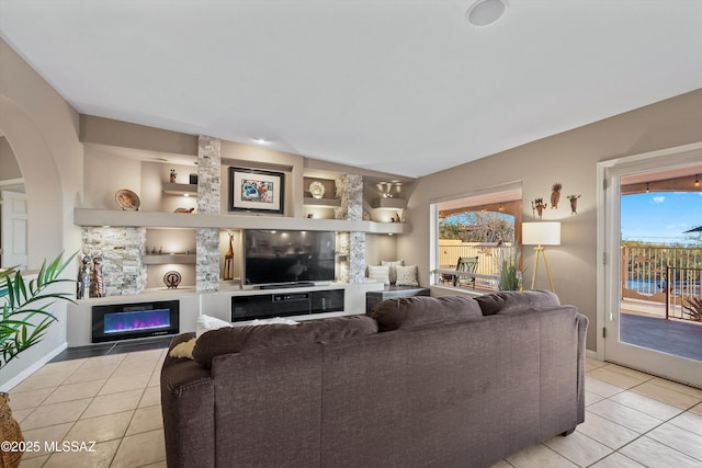 6265 N Jochums Dr, Tucson, AZ 85718 - tiled living area featuring healthy amount of natural light, a glass covered fireplace, and arched walkways