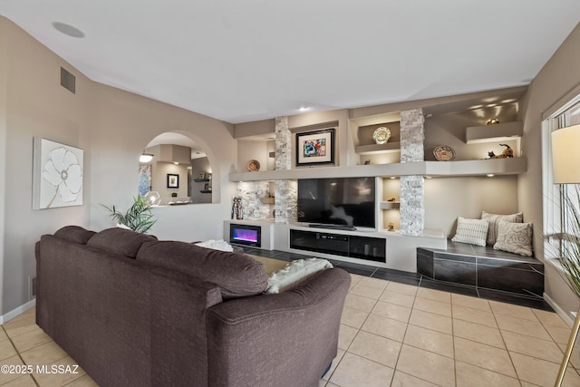 6265 N Jochums Dr, Tucson, AZ 85718 - tiled living room with arched walkways and built in shelves