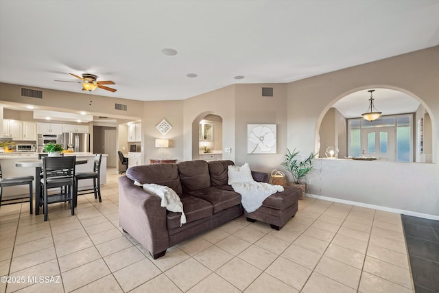 6265 N Jochums Dr, Tucson, AZ 85718 - living room featuring light tile patterned floors, arched walkways, and a ceiling fan
