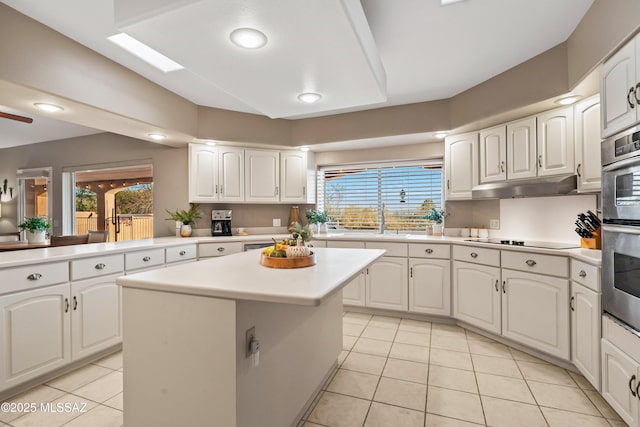 6265 N Jochums Dr, Tucson, AZ 85718 - kitchen with light tile patterned floors, a kitchen island, light countertops, white cabinetry, and recessed lighting