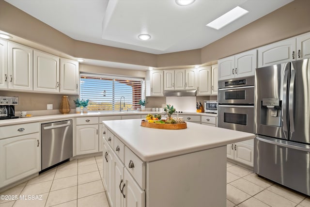 6265 N Jochums Dr, Tucson, AZ 85718 - kitchen with stainless steel appliances, light tile patterned floors, white cabinets, light countertops, and a kitchen island