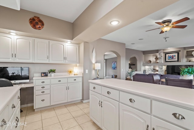 6265 N Jochums Dr, Tucson, AZ 85718 - kitchen featuring arched walkways, a ceiling fan, light countertops, light tile patterned flooring, and white cabinets