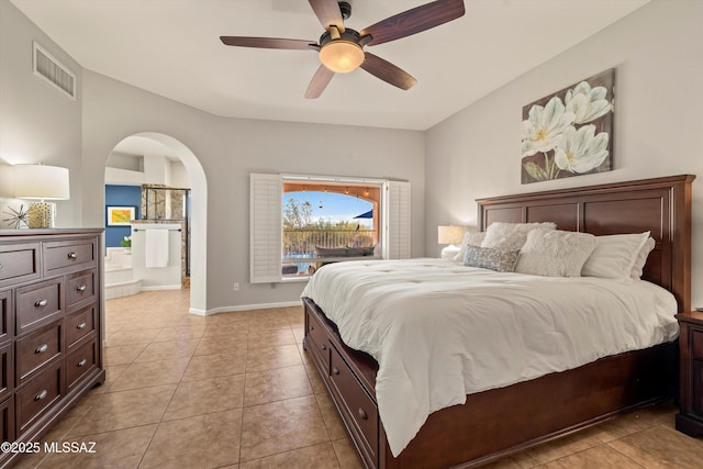 6265 N Jochums Dr, Tucson, AZ 85718 - bedroom with light tile patterned floors, arched walkways, ensuite bath, and ceiling fan