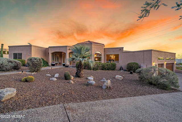 6265 N Jochums Dr, Tucson, AZ 85718 - view of front of house featuring stucco siding, an attached garage, and driveway