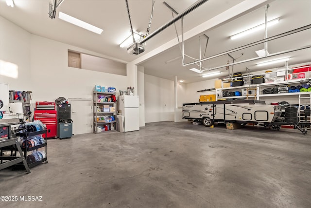 6265 N Jochums Dr, Tucson, AZ 85718 - garage featuring freestanding refrigerator, a garage door opener, and a workshop area