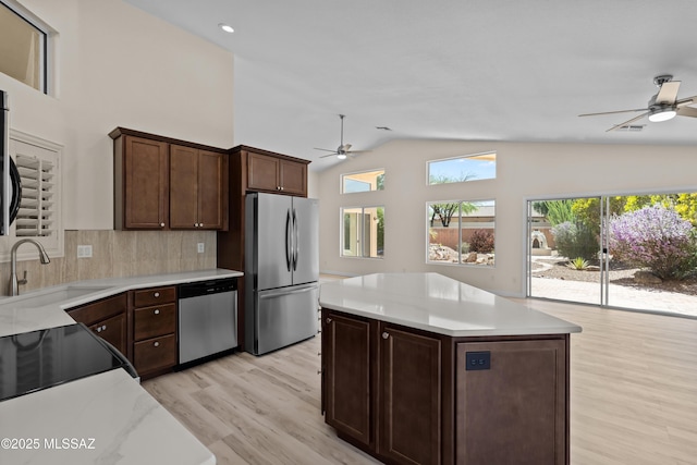 1993 E Desert Lark Pass, Green Valley, AZ 85614 - kitchen featuring appliances with stainless steel finishes, a ceiling fan, lofted ceiling, light wood finished floors, and light countertops