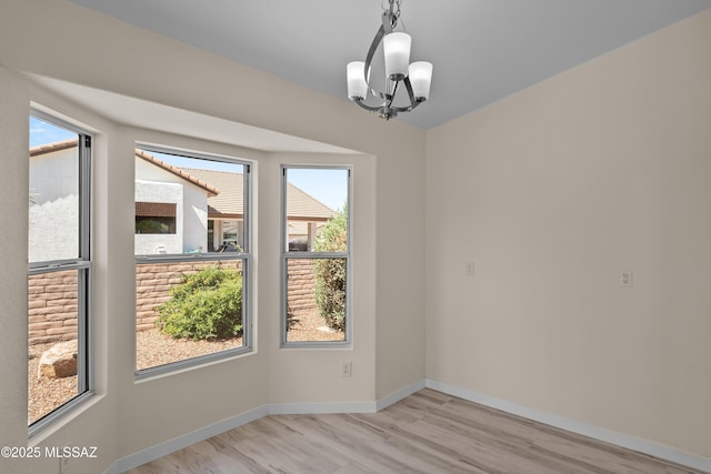1993 E Desert Lark Pass, Green Valley, AZ 85614 - unfurnished room with a chandelier and light wood-type flooring