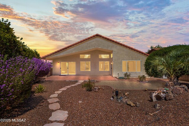 1993 E Desert Lark Pass, Green Valley, AZ 85614 - back of property at dusk featuring stucco siding and a tile roof