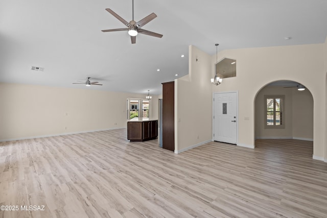 1993 E Desert Lark Pass, Green Valley, AZ 85614 - unfurnished living room with a ceiling fan, arched walkways, high vaulted ceiling, healthy amount of natural light, and light wood-style flooring