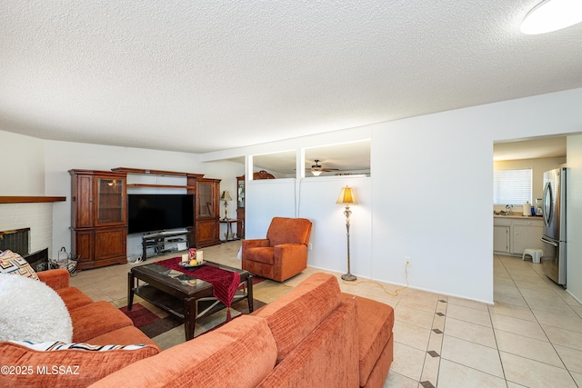 5521 E Camden St, Tucson, AZ 85712 - living area featuring light tile patterned floors, a textured ceiling, ceiling fan, and a fireplace
