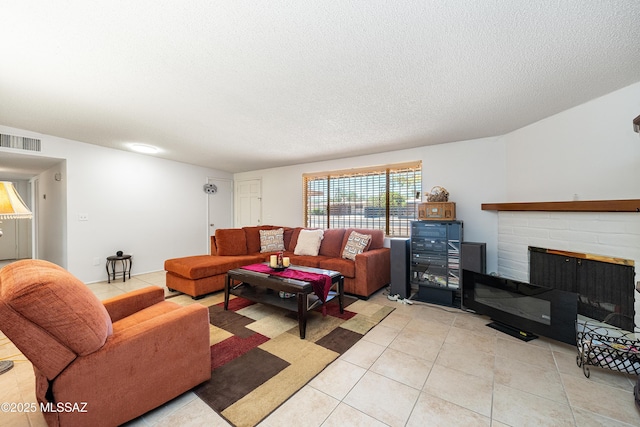 5521 E Camden St, Tucson, AZ 85712 - living room with light tile patterned flooring, a brick fireplace, and a textured ceiling