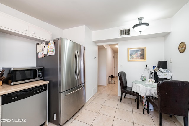 5521 E Camden St, Tucson, AZ 85712 - kitchen with appliances with stainless steel finishes, light countertops, light tile patterned flooring, and white cabinets