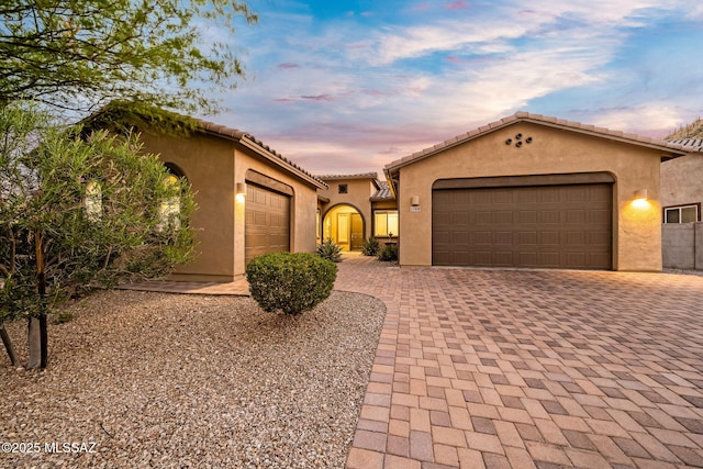 1144 S Castar Dr, Tucson, AZ 85745 - mediterranean / spanish home with an attached garage, stucco siding, decorative driveway, and a tile roof