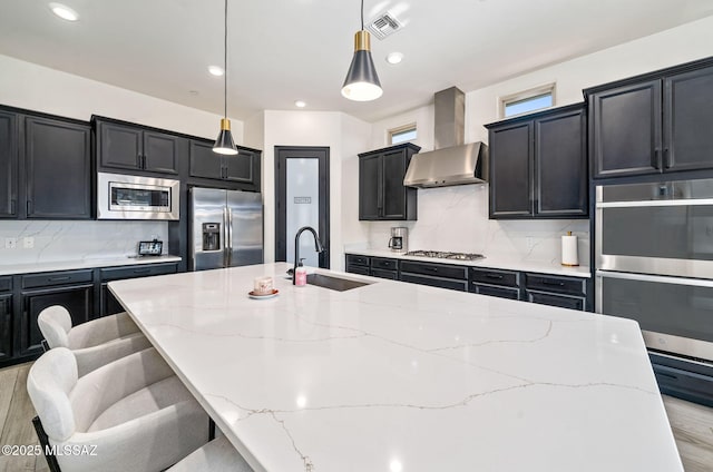 1144 S Castar Dr, Tucson, AZ 85745 - kitchen with stainless steel appliances, wall chimney range hood, dark cabinetry, a spacious island, and backsplash