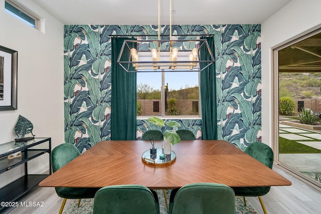1144 S Castar Dr, Tucson, AZ 85745 - dining room with wallpapered walls, an accent wall, plenty of natural light, a chandelier, and wood finished floors