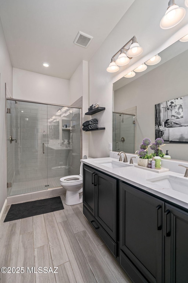 1144 S Castar Dr, Tucson, AZ 85745 - bathroom featuring double vanity, a shower stall, and wood finished floors