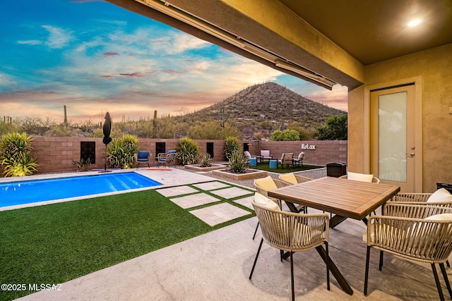 1144 S Castar Dr, Tucson, AZ 85745 - pool at dusk featuring a patio, a fenced backyard, outdoor dining area, and a mountain view