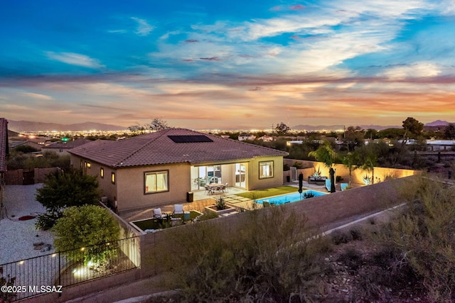 1144 S Castar Dr, Tucson, AZ 85745 - rear view of house with roof mounted solar panels, a tiled roof, a patio, and a fenced backyard
