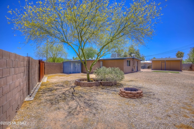 626 S Kellond Pl, Tucson, AZ 85710 - fenced backyard with a storage unit and a fire pit