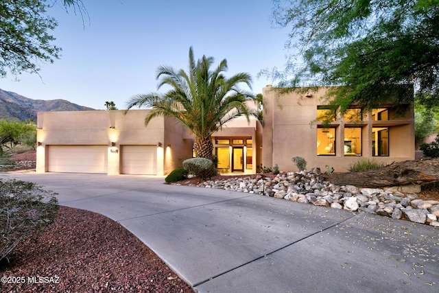6530 N Finisterra, Tucson, AZ 85750 - view of front of property featuring driveway, a garage, stucco siding, and a mountain view