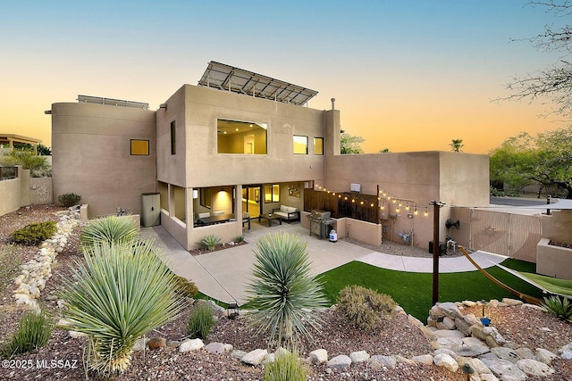 6530 N Finisterra, Tucson, AZ 85750 - back of house at dusk featuring a patio and stucco siding