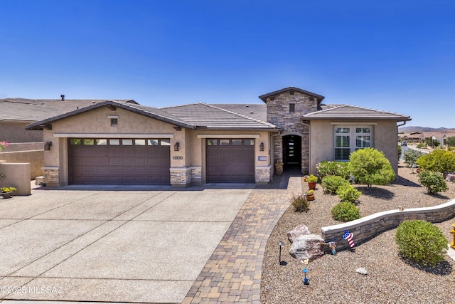 31618 S Tamarisk Pl, Oracle, AZ 85623 - view of front of home featuring an attached garage, stucco siding, concrete driveway, stone siding, and a tile roof